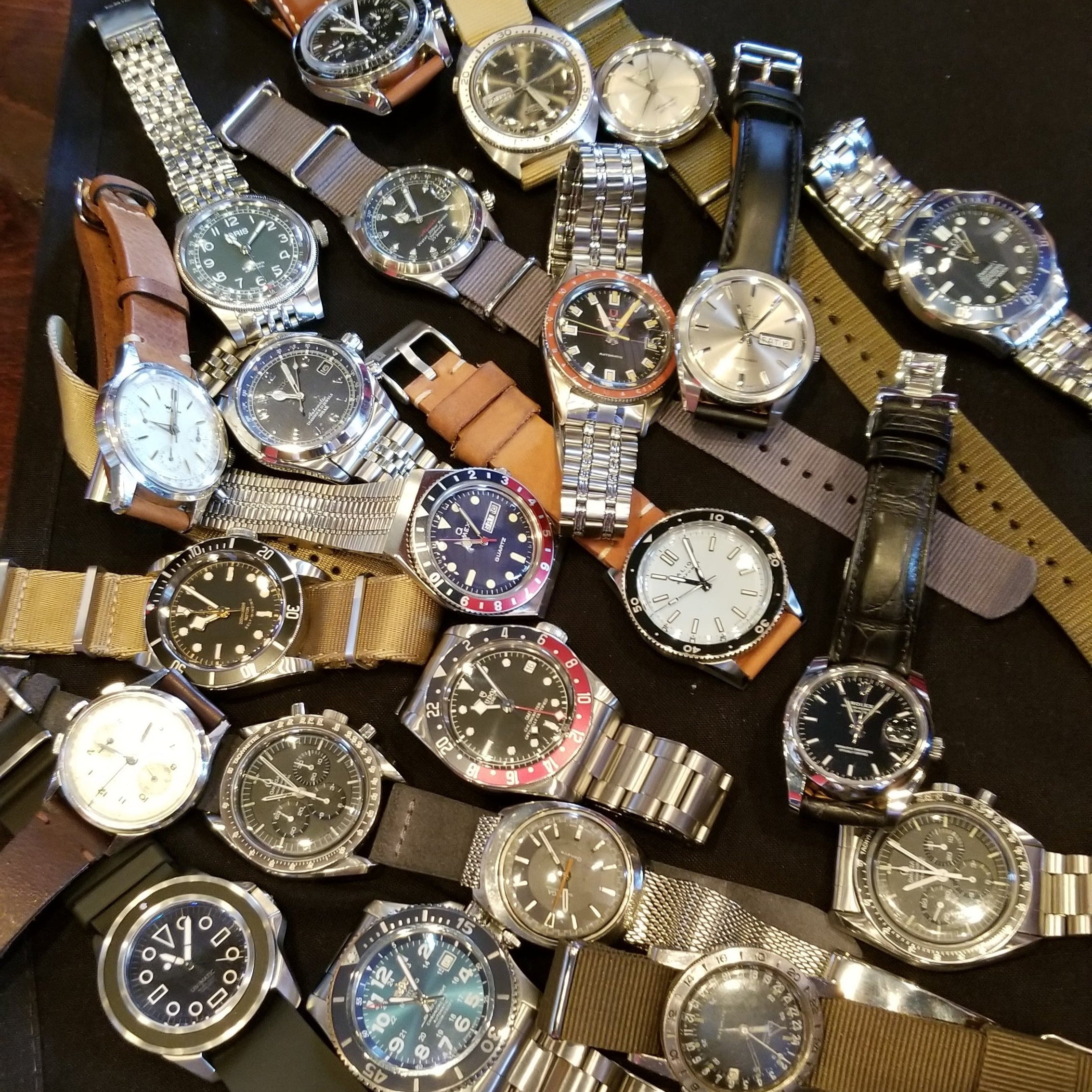 Collection of various watches on a dark surface